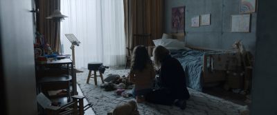 Still from Tár (2022) that has been tagged with: toys & bed & day & over-the-shoulder